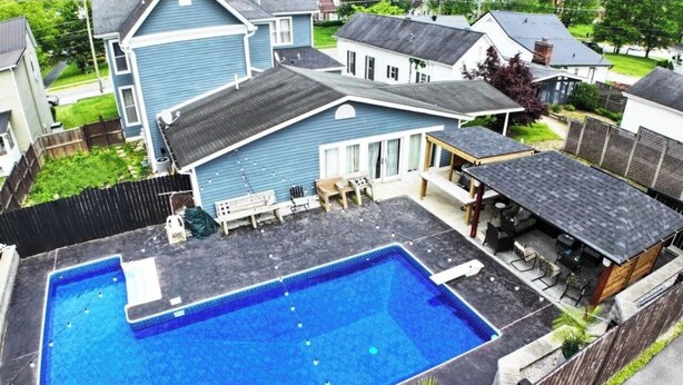 A rectangular swimming pool with a white deck and a slide, surrounded by a wooden fence. - Traditional Bed & Breakfast in Irvine KY with Swimming pool, Wi-Fi Room 2 (Irvine)