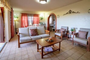 A living room with a sofa, armchairs, a coffee table, and a dining area with a table and chairs. - Nice 2-bedroom house with AC in delightful Saint Johns (Saint Johns)