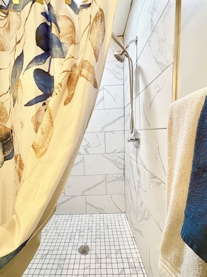 A bathroom with a shower, tiled floor, and a towel rack. - Gorgeous 3-bedroom bungalow with AC in vibrant Atlanta (Atlanta)