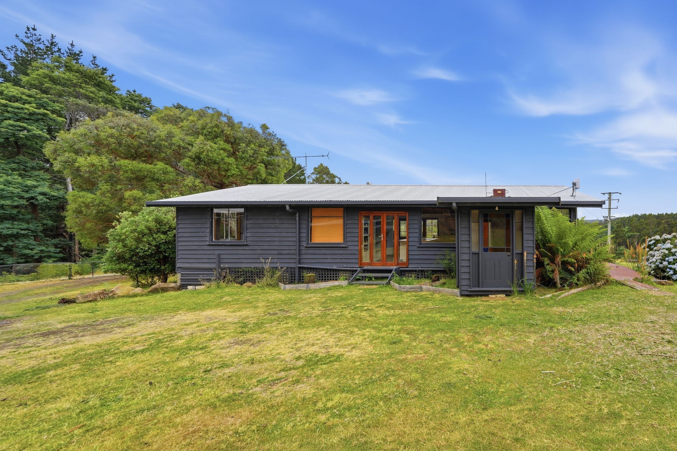 A single-story house with a front porch, a small front yard, and a clear sky.