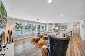 Un salón espacioso con un ventanal grande, un sofá modular y una chimenea.