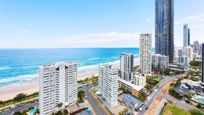 Un paisaje urbano costero con rascacielos, una playa y un cielo azul despejado.