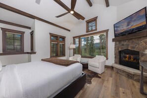 A bedroom with a bed, two chairs, a fireplace, and a TV. - Unmatched Elegance, Views, Amenities, and Location! (Breckenridge)