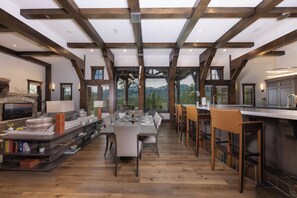 A spacious dining area with a high ceiling and exposed wooden beams, overlooking a scenic mountain view. - Unmatched Elegance, Views, Amenities, and Location! (Breckenridge)