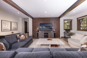 Una sala moderna con un sofá modular, una mesa de centro, un televisor y una chimenea.