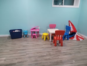 A room with a blue wall, a window, a wooden floor, and a table with chairs. - Room-charming Home in North Edmonton (Edmonton)