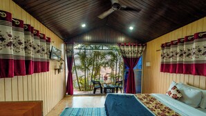 Una habitación con cama, escritorio y vista a palmeras.