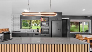 Una cocina moderna con una isla central, electrodomésticos integrados y vistas al exterior.
