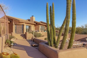 A desert-style house with a patio, cacti, and a clear blue sky. - NEW 6BR Carefree Estate with Views | Tennis, Pickleball, Pool, Infinity Spa, Golf & Views (Carefree)