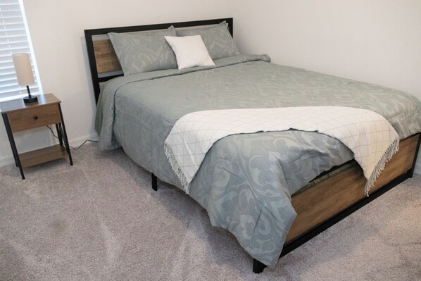 A bedroom with a bed, a nightstand, and a lamp. - Centrally located Relax Zone 3-bedroom house in Palm Bay (Palm Bay)