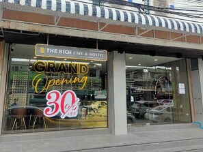 A storefront with a sign indicating a grand opening and a 30% discount. - The Rich Cafe & Hostel (Pattaya)