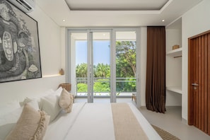 Un dormitorio con una cama grande, un gran ventanal corredizo a un balcón y una puerta de madera.