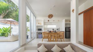 Una sala de estar moderna con un sofá, una mesa de comedor y una cocina al fondo.