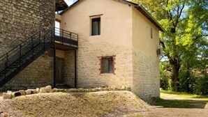 A stone building with a modern extension, a staircase, and a small window.