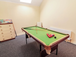 A pool table with balls, a bookshelf, and a radiator. - MACMATHUNA, family friendly, with a garden in Kilrush, County Clare (Kilrush)