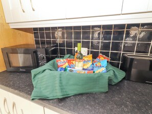 A kitchen with a microwave, toaster, and a green cloth on the counter. - MACMATHUNA, family friendly, with a garden in Kilrush, County Clare (Kilrush)