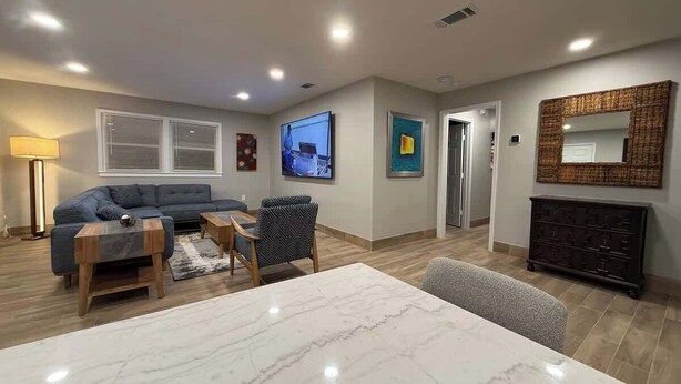 Een moderne woonkamer met een marmeren tafel, een bank en een televisie.