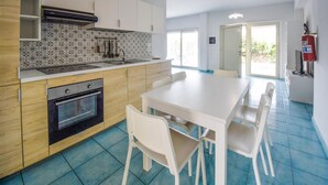 Una cocina moderna con comedor, que incluye estufa, horno y salpicadero de azulejos.