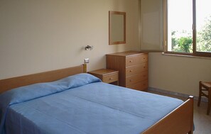 A bedroom with a bed, a dresser, a nightstand, a mirror, and a window. - Lovely apartment in Ricadi with WiFi (Ricadi)