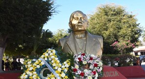 Una estàtua amb un arranjament floral al davant.
