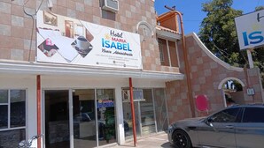 Un edificio con el letrero del Hotel Maria Isabel, que cuenta con una nueva administración, Wi-Fi gratuito y estacionamiento privado.