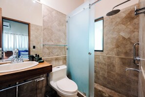 A bathroom with a sink, toilet, shower, and a mirror. - Casa Palmas. Beachfront Villa Escape w/ Private Pool & Direct Beach Access (Tamarindo)