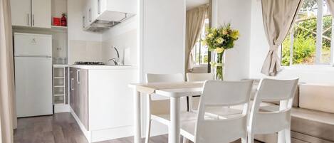 A modern kitchen with white cabinets, a built-in oven, and a gas stove.