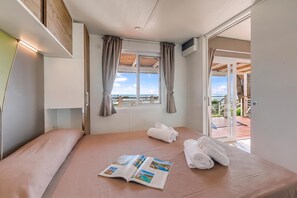 A hotel room with a bed, a window with curtains, a view of the sea, and a door leading to an outdoor area. - Sea View - 40 Parallelo - Deluxe 21, Marina di Camerota, Italy (Marina di Camerota)