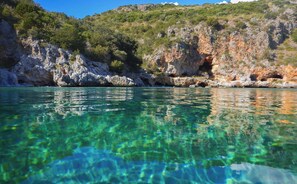 A coastal landscape with clear water, rocky cliffs, and greenery. - Sea View - 40 Parallelo - Deluxe 20, Marina di Camerota, Italy (Marina di Camerota)