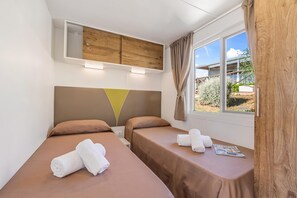 A hotel room with two beds, a wooden headboard, a window with curtains, and a view of the outside. - Sea View - 40 Parallelo - Superior+ 17, Marina di Camerota, Italy (Marina di Camerota)