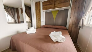 A hotel room with a bed, wooden headboard, and a window with curtains. - Sea View - 40 Parallelo - Superior+ 17, Marina di Camerota, Italy (Marina di Camerota)