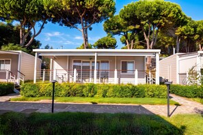 A modern, two-story building with a covered patio area, surrounded by lush greenery and trees. - Sea View - 40 Parallelo - Superior+ 17, Marina di Camerota, Italy (Marina di Camerota)