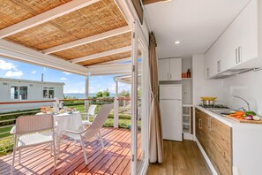 A modern kitchen with white cabinets and a wooden deck. - Sea View - 40 Parallelo - Superior+ 17, Marina di Camerota, Italy (Marina di Camerota)