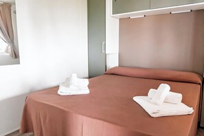 A hotel room with a bed, a table, and a window with curtains. - Sea View - 40 Parallelo - Superior+ 16, Marina di Camerota, Italy (Marina di Camerota)