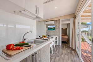 Eine moderne Küche mit Einbauofen, Spüle und Essbereich mit Tisch und Stühlen.