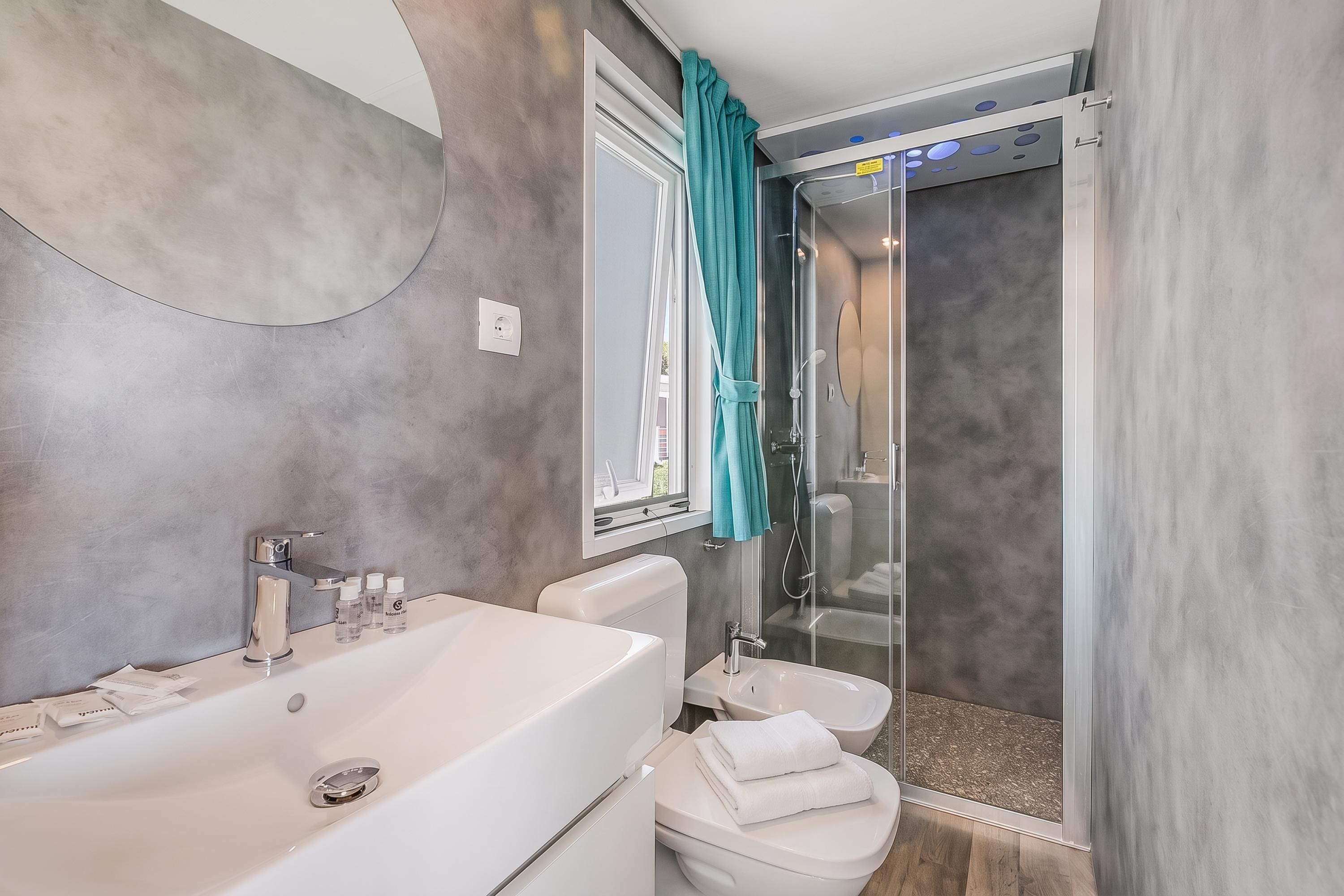 A modern bathroom with a bathtub, toilet, and shower area.