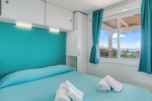 Een hotelkamer met een bed, een raam met gordijnen en uitzicht op het buiten.