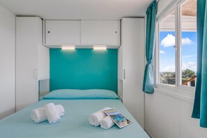A single bed with a teal headboard, white bedding, and a window with curtains. - Sea View - 40 Parallelo - Premium 14, Marina di Camerota, Italy (Marina di Camerota)