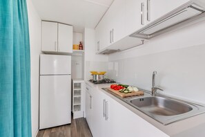 A compact kitchen with white cabinetry, a stainless steel sink, and a gas stove. - Sea View - 40 Parallelo - Premium 14, Marina di Camerota, Italy (Marina di Camerota)