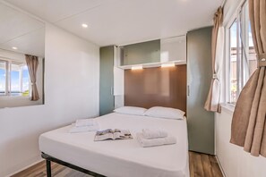 A hotel room with a bed, a window with curtains, a bedside table, and a mirror. - Sea View - 40 Parallelo - Superior 13, Marina di Camerota, Italy (Marina di Camerota)