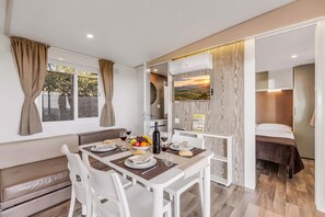 A compact living space with a dining area, kitchenette, and a bedroom. - Sea View - 40 Parallelo - Superior 12, Marina di Camerota, Italy (Marina di Camerota)