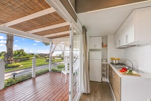 A modern kitchen with a view of a garden and a balcony. - Sea View - 40 Parallelo - Superior 11, Marina di Camerota, Italy (Marina di Camerota)