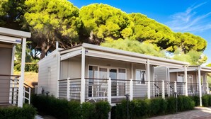 A row of modern, single-story cabins with a covered porch and a stone-paved walkway. - Sea View - 40 Parallelo - Superior 11, Marina di Camerota, Italy (Marina di Camerota)