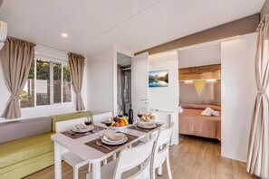 A modern, well-lit room with a dining area, a sofa, and a bed. - Sea View - 40 Parallelo - Superior 11, Marina di Camerota, Italy (Marina di Camerota)