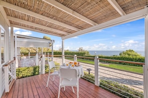A covered outdoor seating area with a table set for two, overlooking a scenic view of the sea. - Sea View - 40 Parallelo - Superior 11, Marina di Camerota, Italy (Marina di Camerota)
