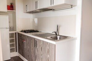 A modern kitchen with white cabinets, a stainless steel sink, and a gas stove. - Sea View - 40 Parallelo - Superior 10, Marina di Camerota, Italy (Marina di Camerota)