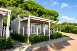 A modern, single-story mobile home with a covered porch, a stone pathway, and a lush green backdrop. - Sea View - 40 Parallelo - Superior 10, Marina di Camerota, Italy (Marina di Camerota)