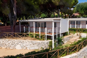 A modern outdoor seating area with a stone wall and wooden railing.