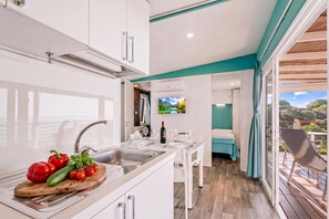 A modern kitchen with a dining area and a bedroom.