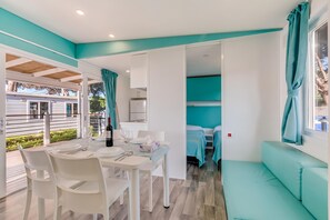 Um interior moderno com área de refeições, cozinha compacta e espaço para relaxar.